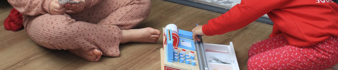 two girls playing with a till educational toy